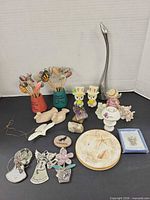 Group shot of all items including metal bird, vases with tulips, figurines, crystals, plate, ornaments and boxed brooch