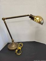 Full view of brass articulating lamp showing arms and shade