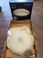 Swirl glass fixture in open box with Artika StarRaker box behind