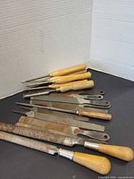 Mix of chisels with wood handles and several metal files laid out