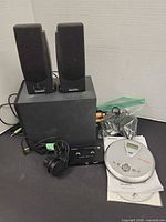 Overall lot showing Altec Lansing subwoofer, two satellite speakers, Sony CD player, manual and accessories