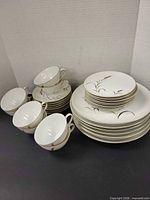 Stacked dinner and salad plates with adjacent cups and saucers showing quantity and condition