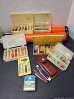 Full lot overview showing rod tubes, tackle boxes, sinkers, hooks, knives, sheath