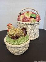 Front view of both ceramic baskets showing lids and wicker-textured bases