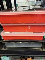 three stacked red 18-compartment organizer cases