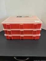 Three red plastic organizer boxes stacked