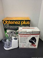 Lot overview showing Philips accessory kit box, Cuisinart hand mixer box, small food processor