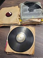 Stack of 78 RPM records in sleeves, top disc without sleeve