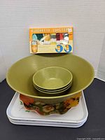group shot of melamine bowls stacked on metal trays with boxed coasters