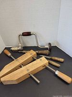 All items together: Jorgensen clamp, brace drill, three wood-handled tools