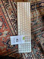 Top view of the Apple wired aluminum keyboard showing full key layout and attached USB cable