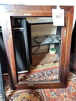 Dark-brown stained wood frame with glass glazing and hanging hardware