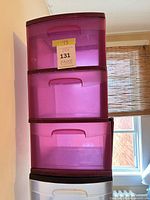 Pink/magenta 3-drawer storage tower stacked on clear tower