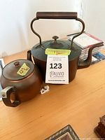Copper teapot and sugar bowl with patina visible