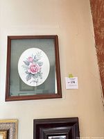 Full view of framed rose print hung on wall