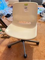 Front view of beige molded plastic office chair on metal swivel base with casters