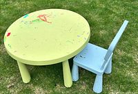 Round green kids table and matching blue chair on grass