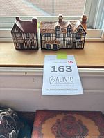 Front view of two ceramic miniature Tudor houses on window ledge