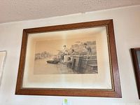 Framed engraving on wall showing full artwork and wood frame