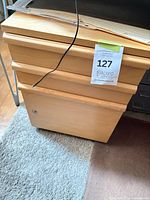 Front view showing three drawers, lock, wood veneer, lot tag