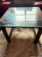 Full view of square wood coffee table with glass insert top