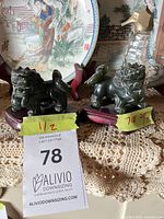 Pair of green stone guardian lion figurines on wooden bases