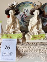 Both figurines side by side showing overall form, bases and hats