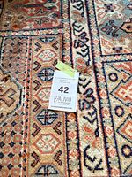 Central field showing geometric motifs and color palette with lot tag visible