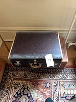 Top view of dark brown suitcase showing surface wear and trim