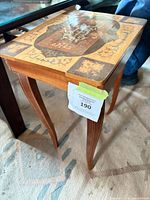 Full view of side table showing inlaid top design and leg style