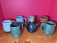 Group view of teapot and six mugs