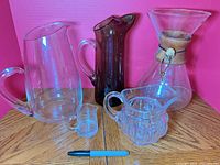 All five glass pieces grouped: Chemex, clear pitcher, amber pitcher, creamer, mini cup