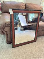 Front view of rectangular mirror with brown wood and marbleized frame