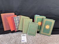 Group shot of eight vintage hardcover books showing front boards and colours