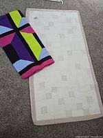 Quilted runner and folded knit throw on carpet