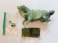 Full view of jade horse, broken base, loose leg fragment in bag