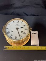 Front view of Schatz Royal Mariner brass ship's clock with measuring tape showing diameter