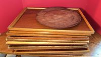 Stack of wooden trays with round piece visible