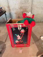 Overall view of boxed animated elves decoration with plush elf visible