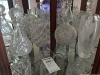 Group view of all four cut and etched glass pieces inside cabinet