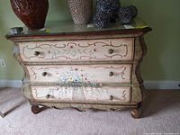 Front view of painted bombe dresser with glass top