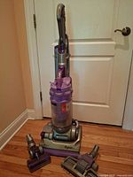 Full view of Dyson Animal upright vacuum with two attachments