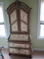 Full view of secretary desk showing upper cabinet, drop-front desk, drawers and decorative painting
