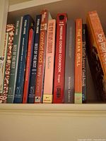 Upright row of cookbooks including Food & Wine series, Comfort Food, Pressure Cooker, Asian Grill, Garlic Lovers