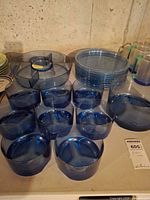 Group view of blue acrylic bowls, plates, divided tray and goblets