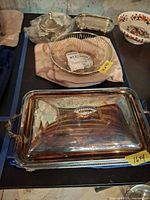Overview of silverplate serving tray, wire bowl, butter dish, pewter bowl