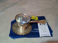 Top view of sterling gravy cup on drip plate with wooden handle