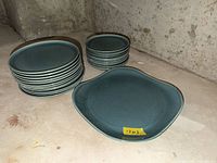 Stack of dinner plates, side plates, and square platter