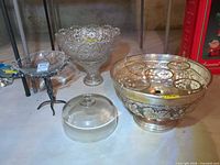 group shot of all four items: silver cooler, compote, cloche, bowl on stand