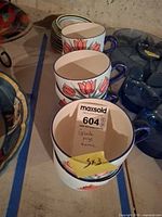 Stack of three large tulip design mugs plus surrounding items